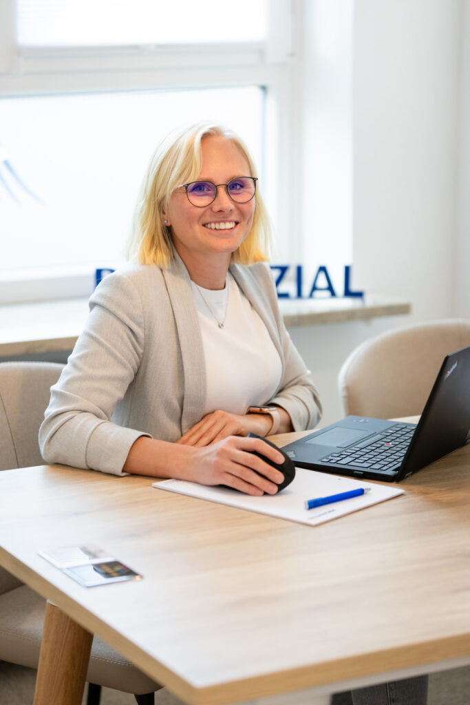 Hochformat-Aufnahme einer Mitarbeiterin im Büro